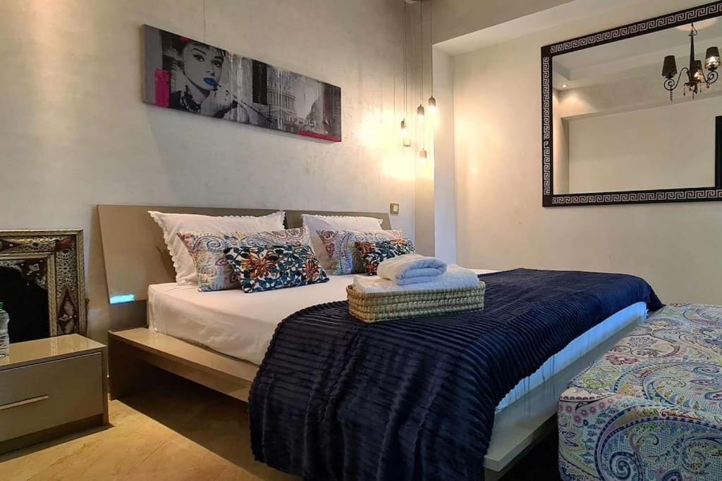 マラケシュにあるLuxueux appartement Marrakech au cœur de l hivernageのベッドルーム1室(ベッド1台、壁掛け鏡付)