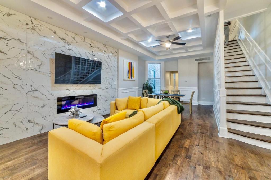 sala de estar con sofá amarillo y pared de piedra en Luxury Chicago TH is a 10-minute drive to DWTN, perfect for city access RSV Now, en Chicago