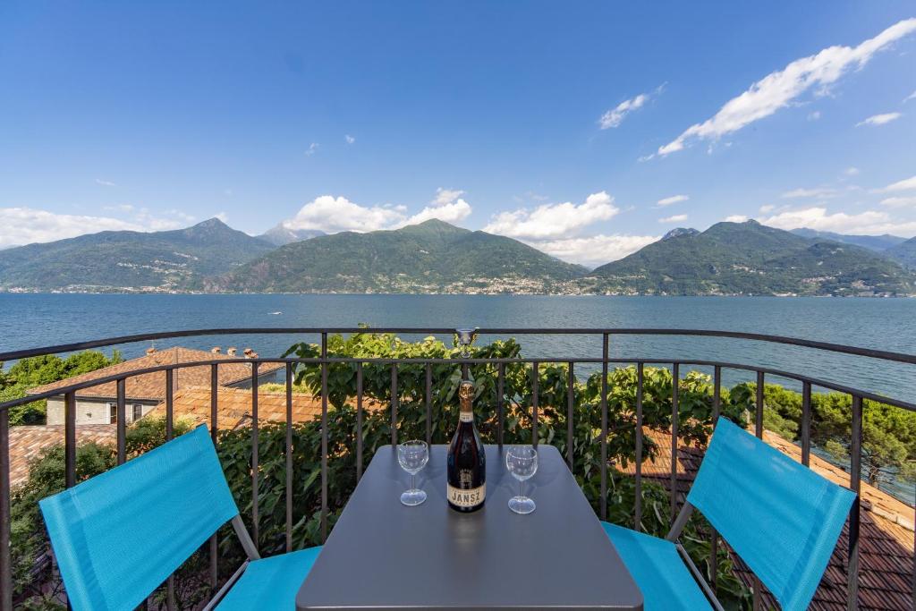 a table with wine glasses on a balcony with a view of the water at Studio Apartment Lake Views in Acquaseria