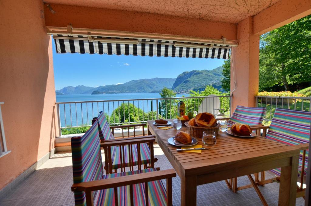 einen Tisch und Stühle auf einem Balkon mit Blick auf das Wasser in der Unterkunft 2-Bedroom Lakeview Apartment Bella Gaeta in San Siro