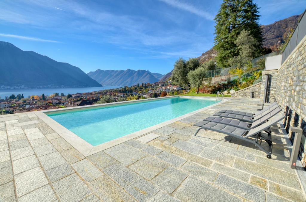 una piscina con vista sull'acqua e sulle montagne di Casa Antonia 2-Bedroom Deluxe Lake View Apartment a Lenno