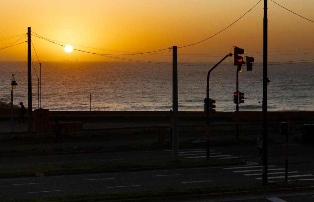 a sunset over the ocean with a traffic light at Un ambiente frente al mar in Mar del Plata