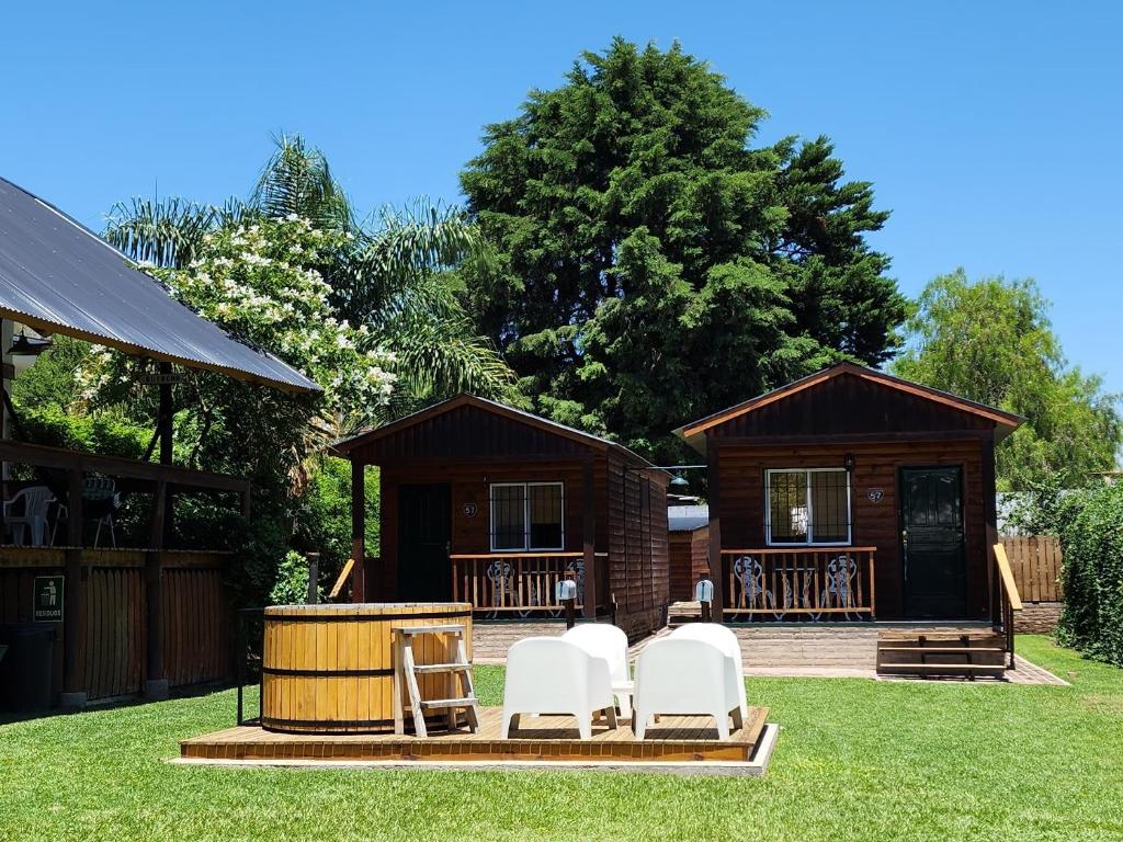 a group of chairs sitting outside of a cabin at Cabañas 57 in Villa Carlos Paz