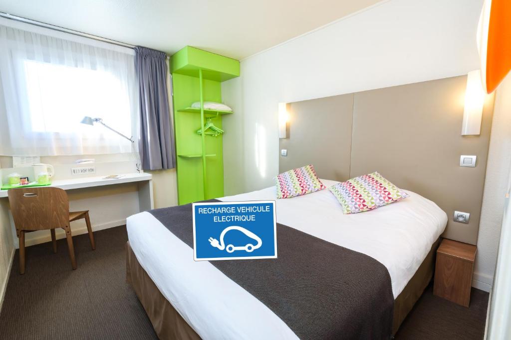 a hotel room with a bed with a sign on it at Campanile Toulouse Purpan in Toulouse