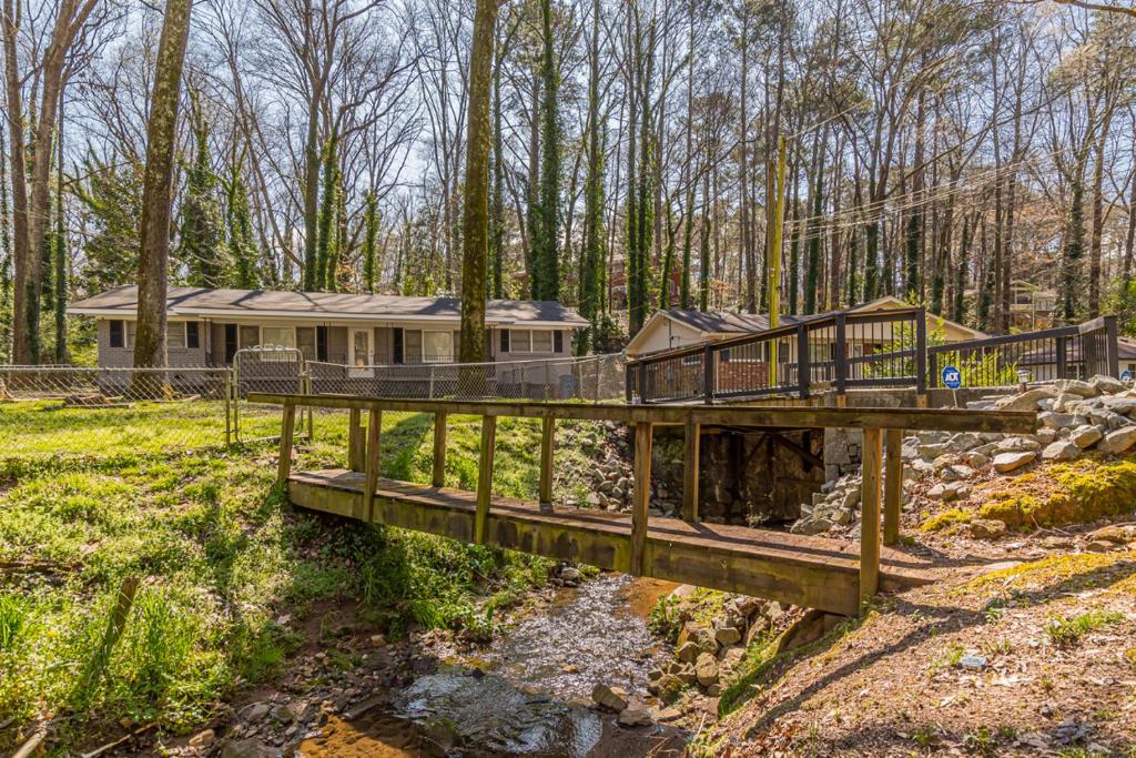 a house in the woods with a bridge over a creek at The Sweet Creek Luxurious Villas in Atlanta