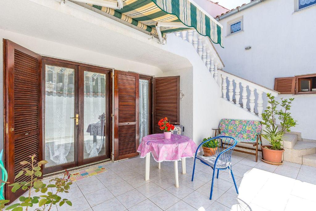 un patio con mesa, sillas y escaleras en Ferienwohnung in bester Lage, nahe dem Meer, en Barbariga