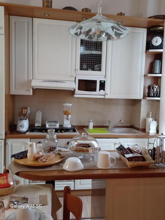 une cuisine avec des placards blancs et un comptoir dans l'établissement B&b Rosy, à Burago di Molgora