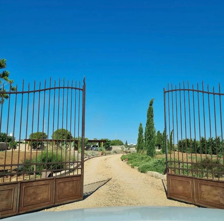 アレーツィオにあるMasseria Li Capperiの植物の未舗装道路につながる門
