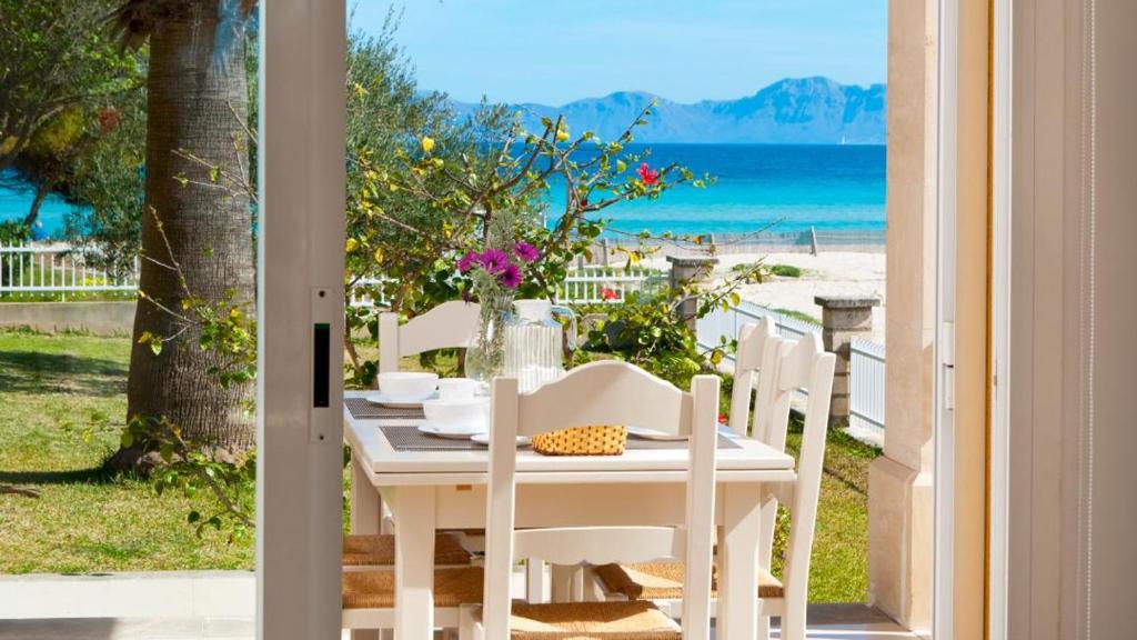 una mesa y sillas blancas con vistas al océano en Sun of the Bay BL3 - Bajos A, en Alcudia