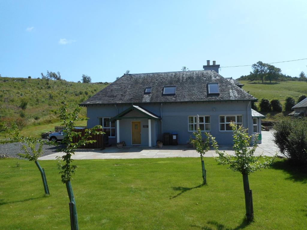 uma casa azul com árvores em frente em Chauffeur's Cottage with Hot Tub em Cray