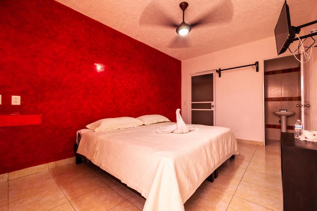 a bedroom with a red wall and a bed at Hotel Bello Caribe Express in Cozumel