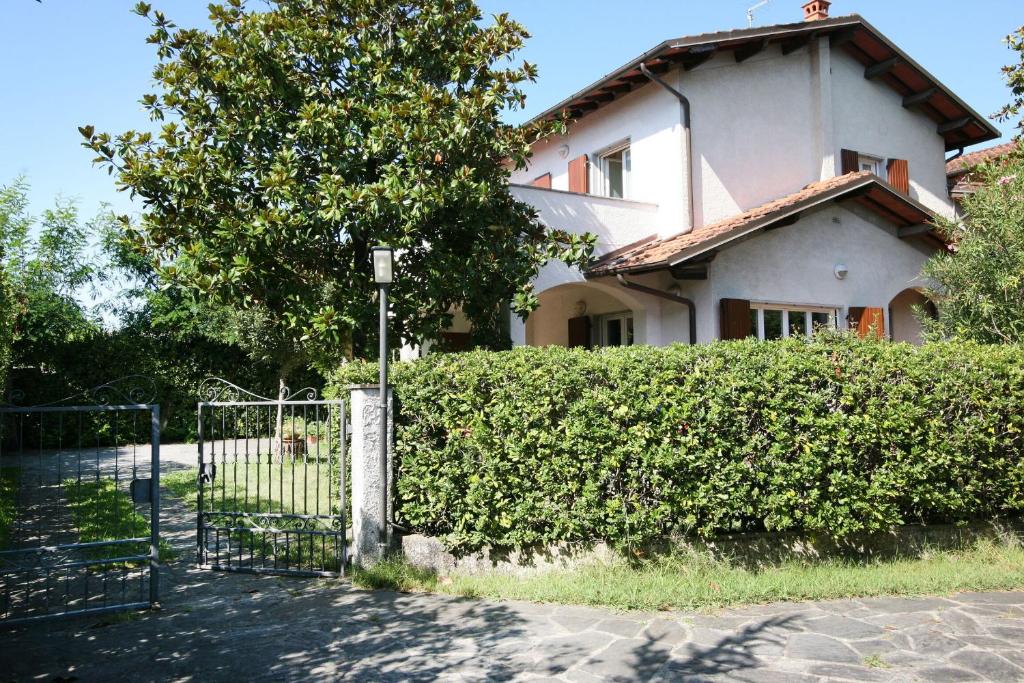 a house with a fence in front of a hedge at Villa Cremona in Forte dei Marmi