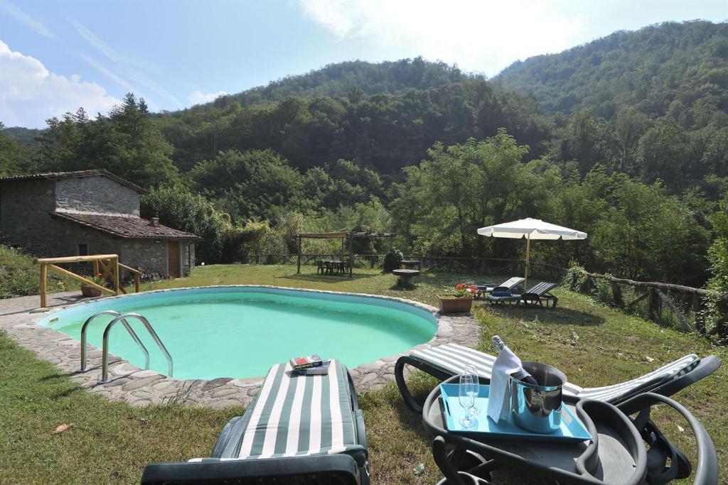 a motorcycle is parked next to a swimming pool at La Casetta in Coreglia Antelminelli