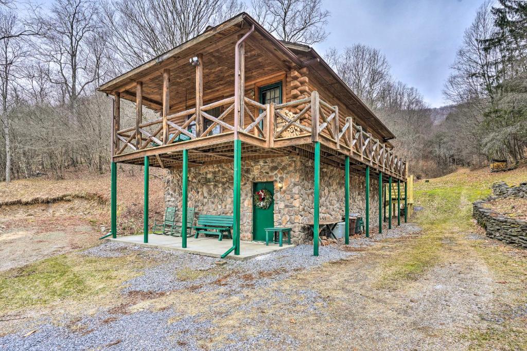 a log cabin with a green bench in front of it at Charming Austin Cabin on 96 Acres of Land! 