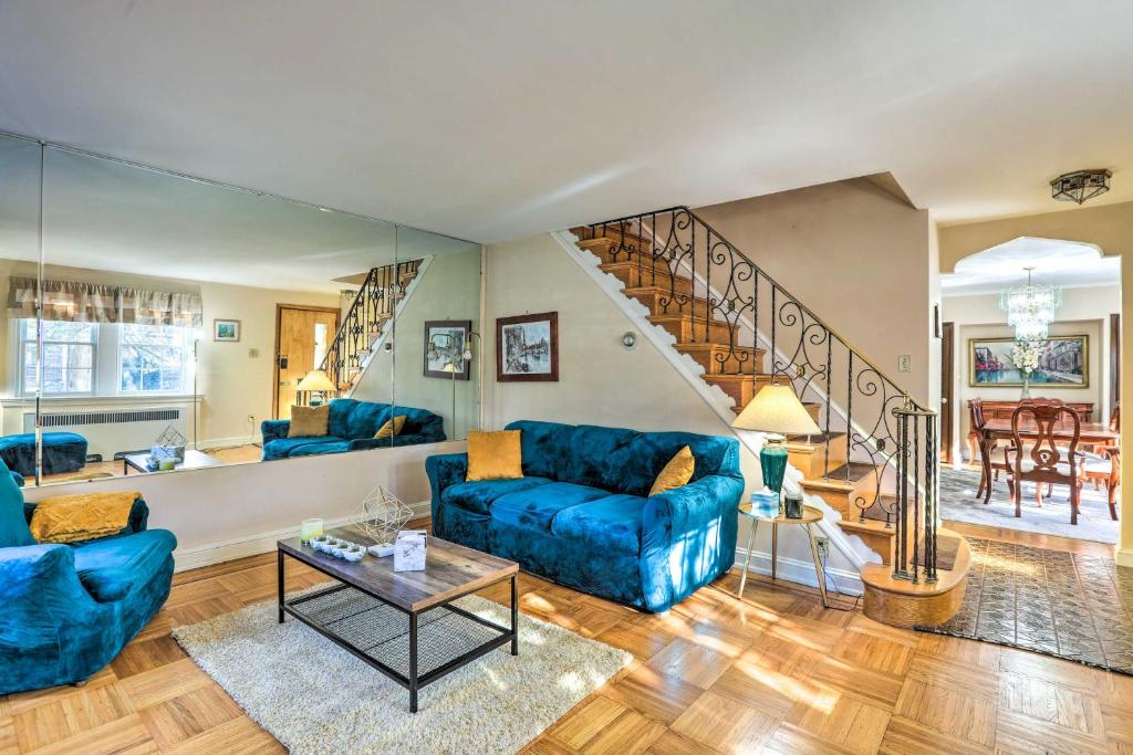 a living room with blue couches and a staircase at Yeadon Townhome with Porch, 7 Mi to Center City in Drexel Hill