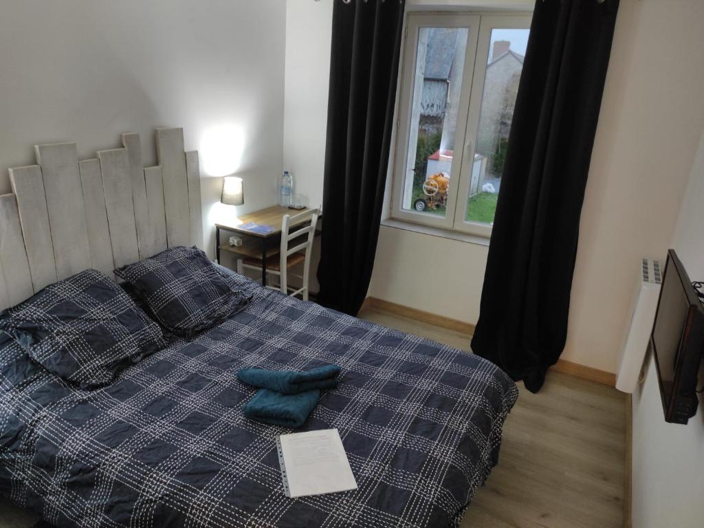 um quarto com uma cama com almofadas azuis e uma janela em Agréable chambre d'hôte 