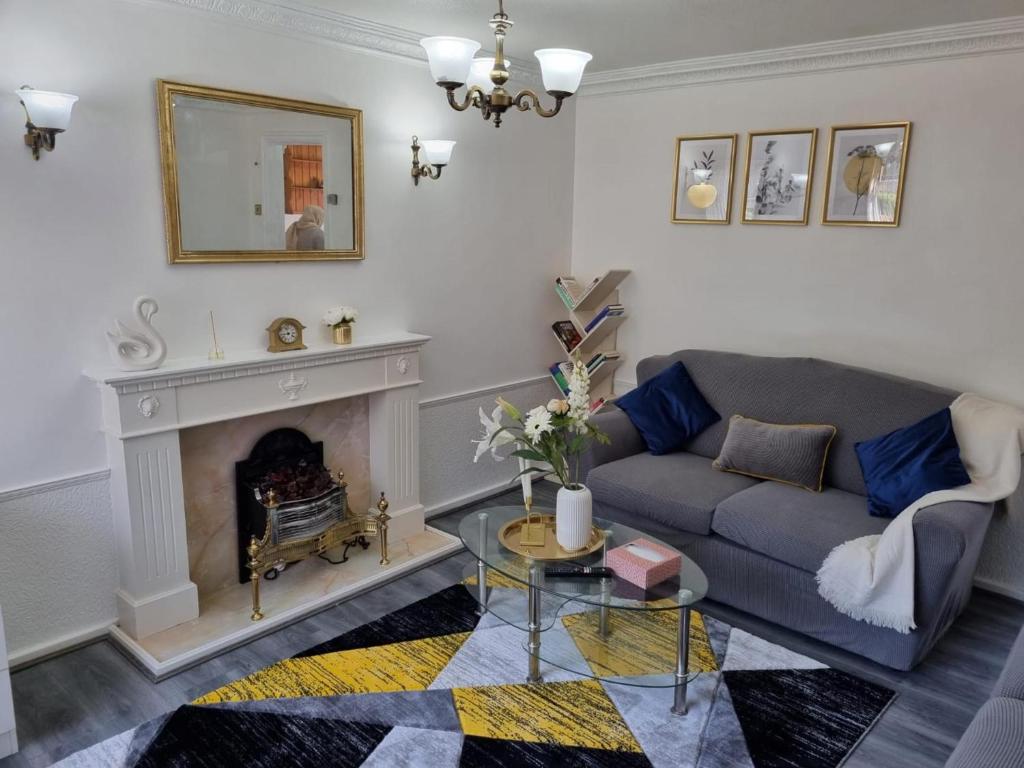 a living room with a couch and a fireplace at Centrally located with free parking and smart Tv in Leeds