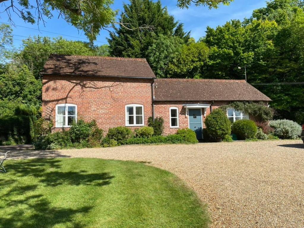 a brick house with a gravel driveway at Stable Cottage Peaceful Stunning Retreat near Bath in Upavon