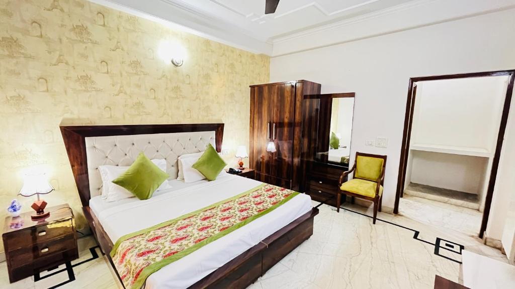 een slaapkamer met een groot bed en een stoel bij Hotel Starline near Iffco Chowk Metro - Couple Friendly in Gurgaon