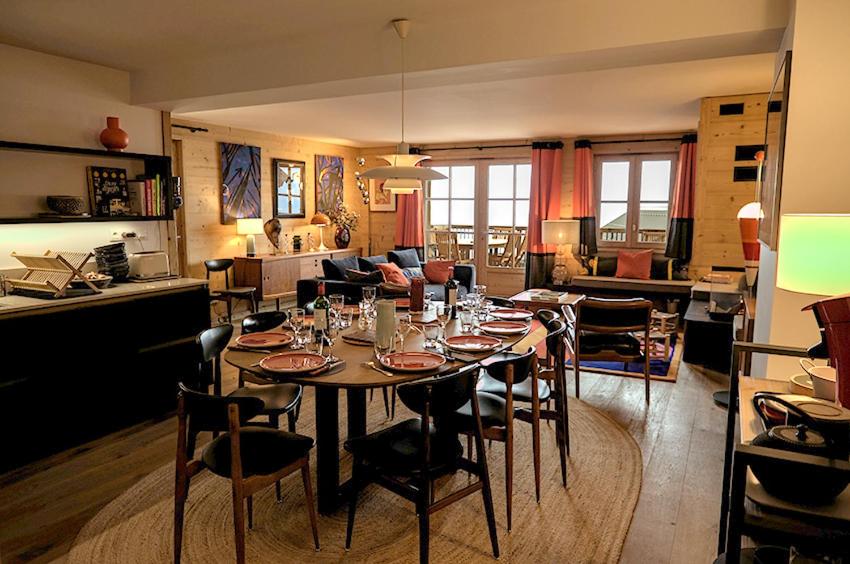 a dining room and living room with a table and chairs at Klochette - Charme et Famille, Appartement 5 étoiles dans Chalet Récent à Villard-Reculas in Villard-Reculas