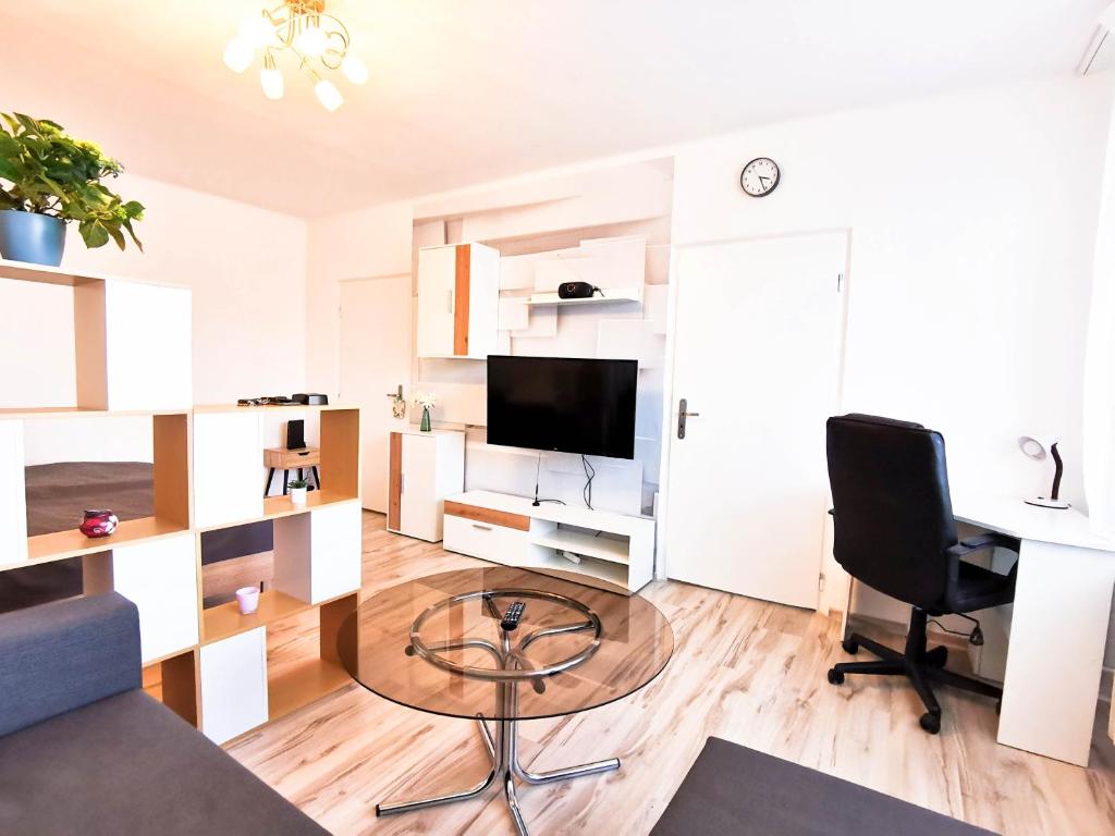 uma sala de estar com uma mesa de vidro e uma televisão em Apartment Hroncová, near city centre and park, quiet location em Košice