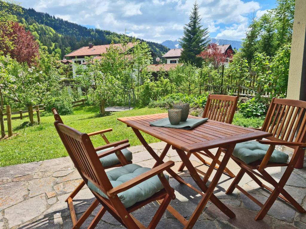 una mesa de madera y sillas en un patio en Ferienwohnung Berglust, en Sachrang