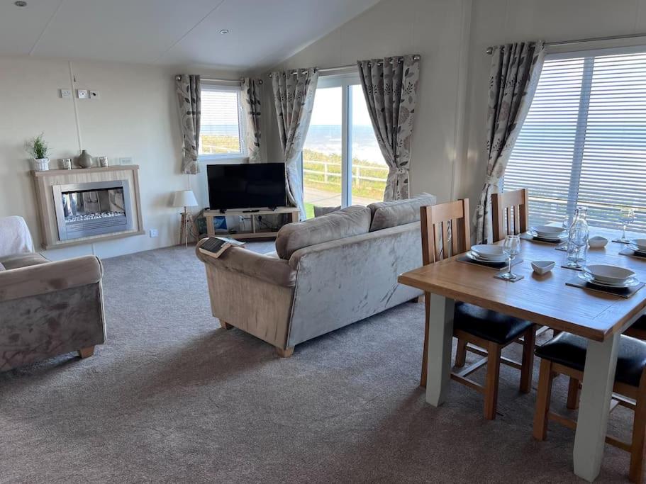 a living room with a couch and a table at Beautiful 2-Bedroom Lodge with Spectacular Views in Hartlepool