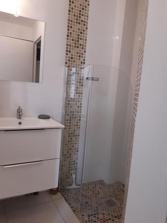 biała łazienka z prysznicem i umywalką w obiekcie Confortable studio bord de mer w mieście Canet-en-Roussillon