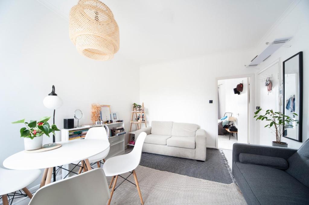 een witte woonkamer met een witte tafel en stoelen bij 1Bed Flat - QUIET Nest - Green Lanes in Londen