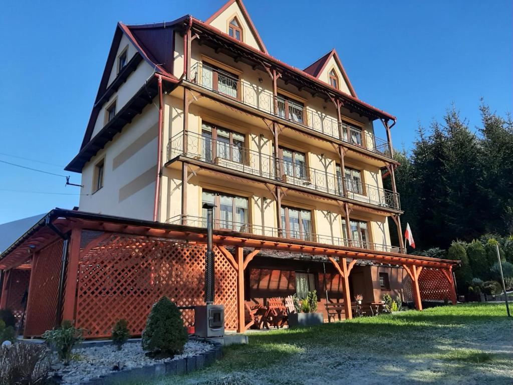 a large building with a balcony on top of it at Agroturystyka U Misia in Niedźwiedź