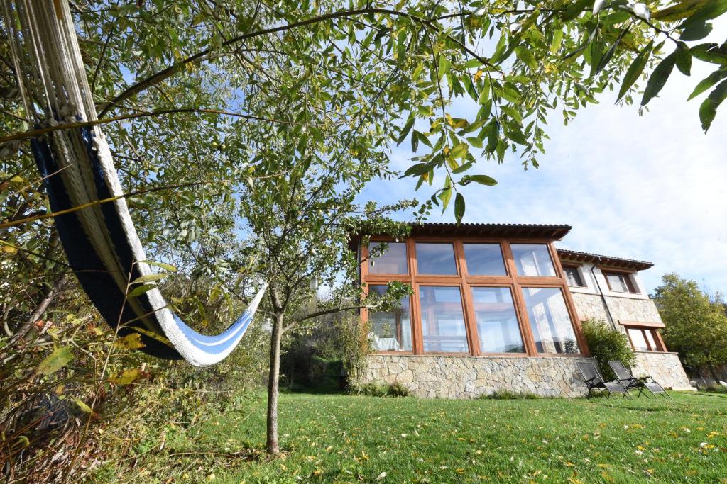 a hammock in front of a house at Ecologica casa del sol in Navacepeda de Tormes