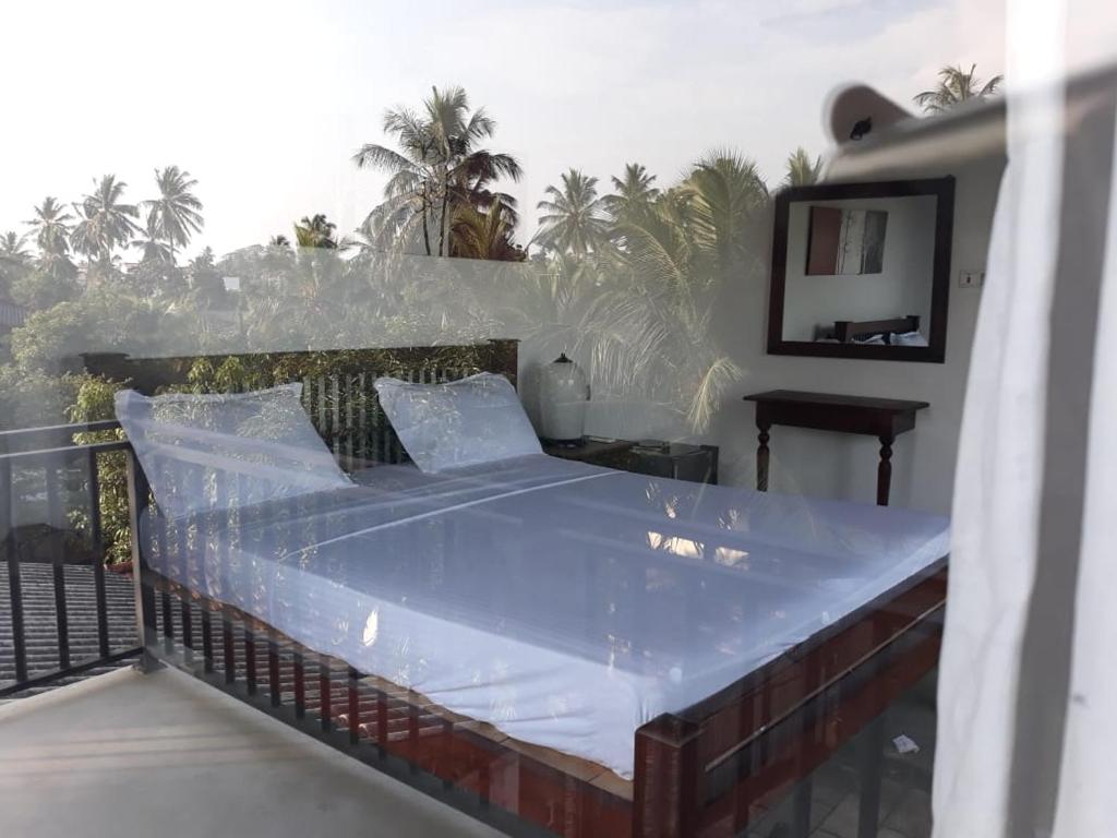 een bed bovenop een balkon bij Mario River Villa in Ambalangoda