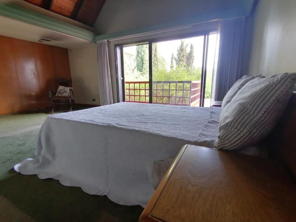 Cama grande en habitación con ventana en PARAISO en Mendoza