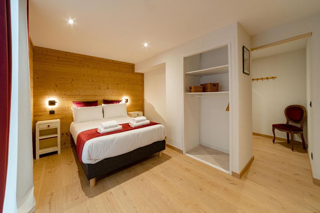 um quarto com uma cama grande e uma parede de madeira em Hôtel Restaurant Le Madame em La Ferrière