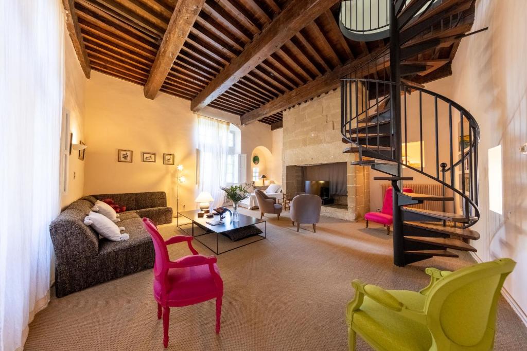 a living room with a staircase and colorful chairs at Monte Arena Chambre d&#39;hôtes in Montaren-et-Saint-Médiers