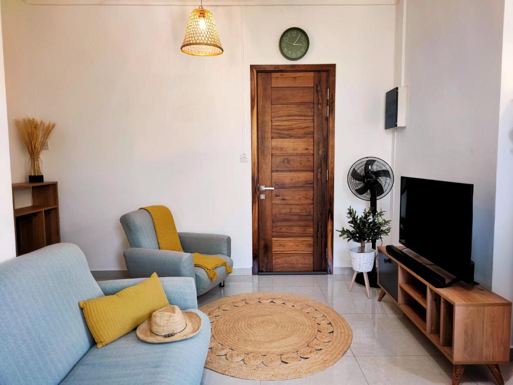 un soggiorno con divano blu e TV di Villa La Tortue - GBH a Grand Baie