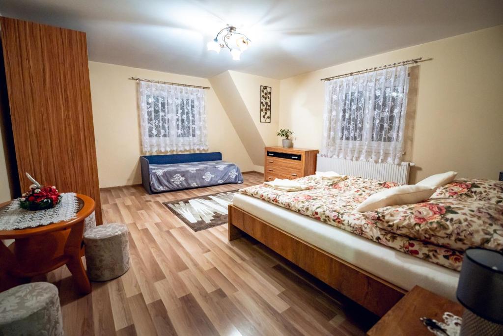 1 dormitorio con 1 cama, 1 mesa y 2 ventanas en Cichy Zakątek, en Ciche