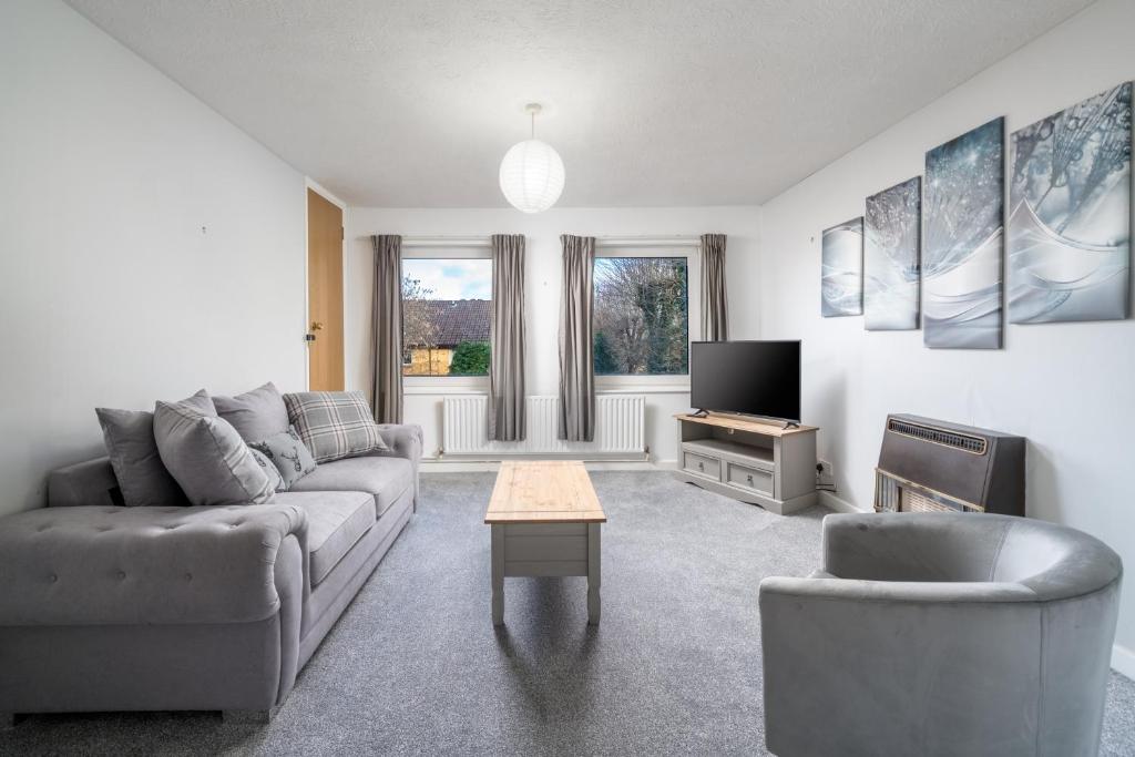ein Wohnzimmer mit einem Sofa und einem TV in der Unterkunft Spacious Pet-Friendly Apartment in Crawley by Sublime Stays in Three Bridges