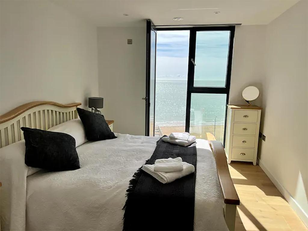 a bedroom with a bed with a view of the ocean at SoHot Stays Royal Sands Seaview Apt Free Parking Sleeps 4 in Ramsgate