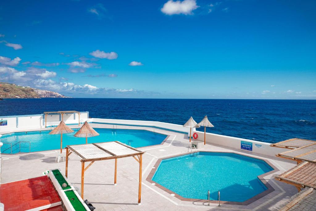 a swimming pool with the ocean in the background at Marina Blue, Las Caletillas in Candelaria