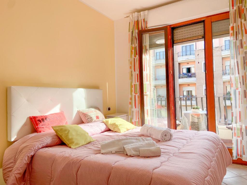 un letto in una camera con una grande finestra di Suite Angeli, a due passi da Assisi a Santa Maria degli Angeli