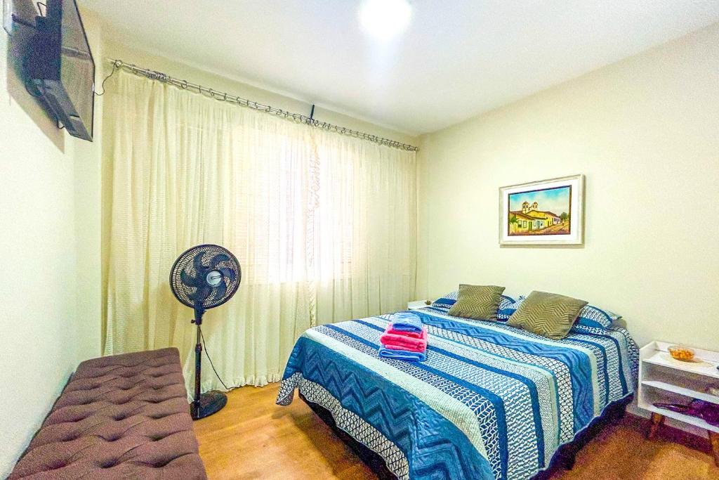 - une chambre avec un lit et un ventilateur dans l'établissement Kitnet com excelente localizacao em Serra Negra SP, à Serra Negra
