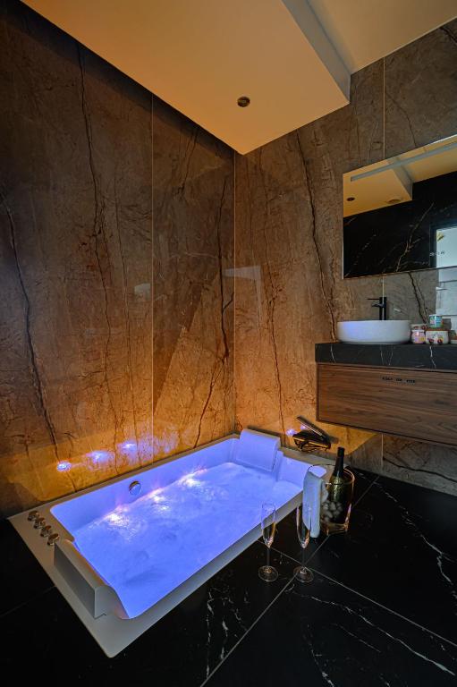 La salle de bains est pourvue d'une grande baignoire et d'un lavabo. dans l'établissement Le Cupidon, En plein Coeur de Lorient, à Lorient