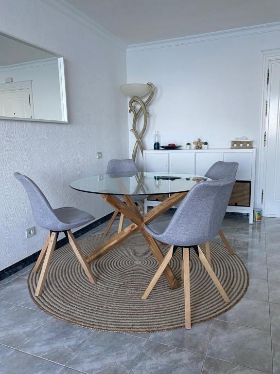 a dining table and two chairs in a room at Direkt am Strand - Playa Patalavaca - Doñana in Patalavaca