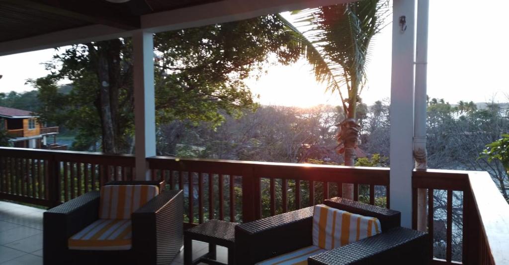 eine Veranda mit Stühlen und Blick auf eine Palme in der Unterkunft Villa #4 - Isla Contadora in Isla Contadora