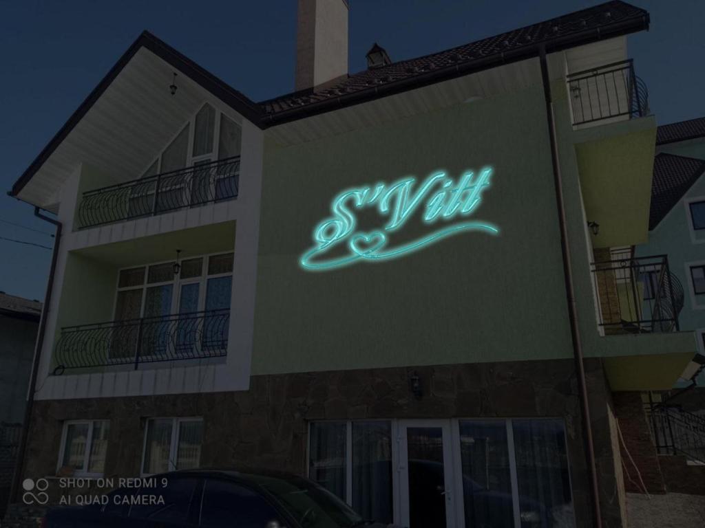 ein Neonschild an der Seite eines Gebäudes in der Unterkunft S'Vitt in Schidnyzja