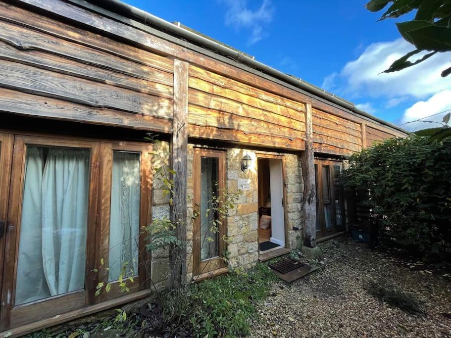 una vecchia casa in legno con finestre sul lato di Escape to a Cosy Country Barn: Discover the Charm of Rustic Living 