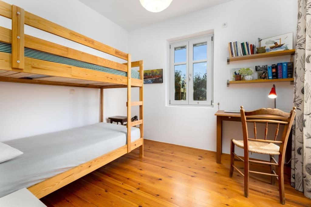 a bedroom with a bunk bed and a desk at Bralos Villa - Paros, Sea View in Kóstos