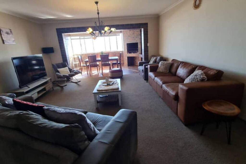a living room with couches and a television and a table at Swakopmund holiday Apartment in Swakopmund