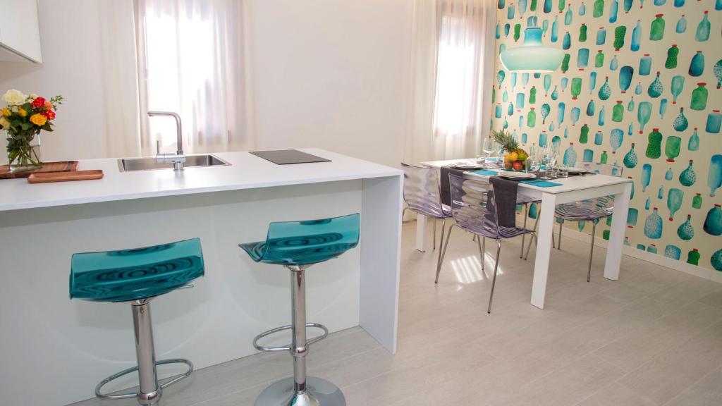 a kitchen with a sink and a table with chairs at Hotel President in Lignano Sabbiadoro